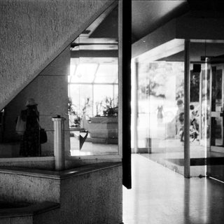 Modernist building lobby with glass partitions and minimalist design.