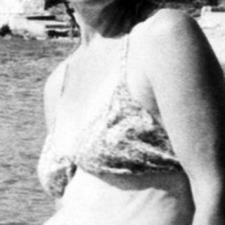 Woman posing at seaside beach with towel.