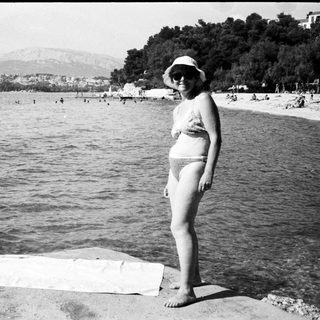 Woman posing at seaside beach with towel.