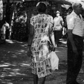 Outdoor market scene with people browsing stalls.