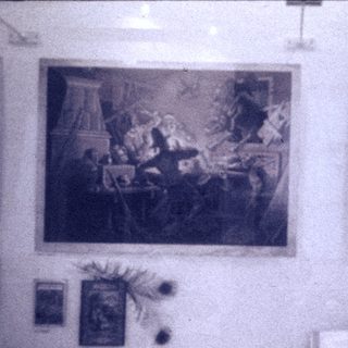 Vintage art exhibition with classical paintings and framed documents.