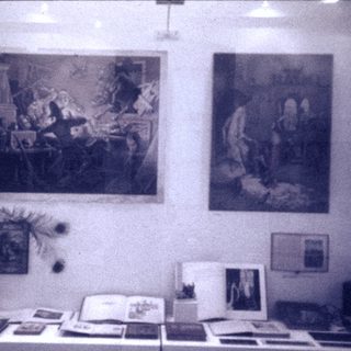 Vintage art exhibition with classical paintings and framed documents.