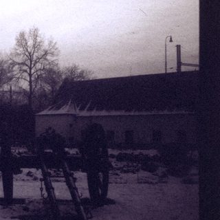 Vintage winter scene of rural buildings and snow-covered landscape.
