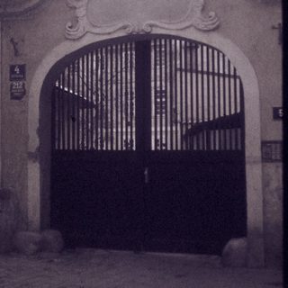 Architectural gate with ornate archway in aged courtyard.