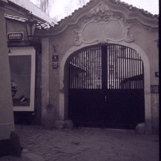 Architectural gate with ornate archway in aged courtyard.