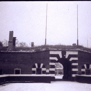 Fortified entrance gate with brick walls and snow.