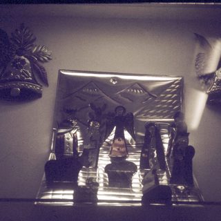 Vintage shrine with religious statues and decorative bells.