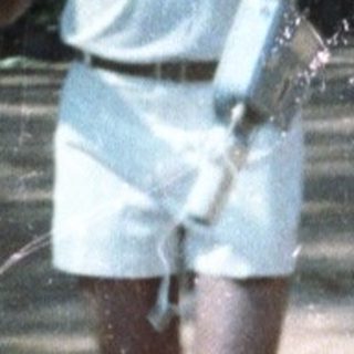 Two people playing tennis on outdoor court.