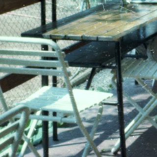 Two elderly people sitting outdoors at a café table.