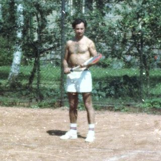Man playing tennis on outdoor court.