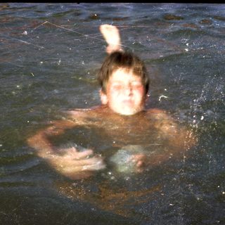 Person swimming underwater holding a ball.
