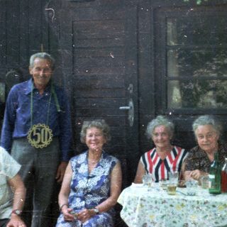Group celebrating outdoors at a rustic table.