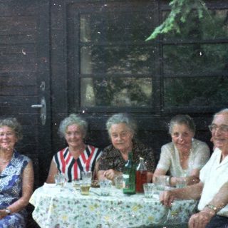 Group celebrating outdoors at a rustic table.