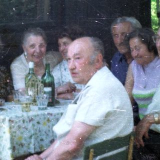 Group of elderly people gathered indoors for a meal.