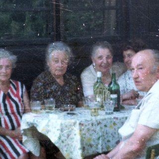 Group of elderly people gathered indoors for a meal.