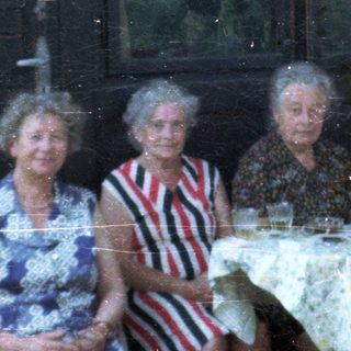 Group of elderly people gathered indoors for a meal.