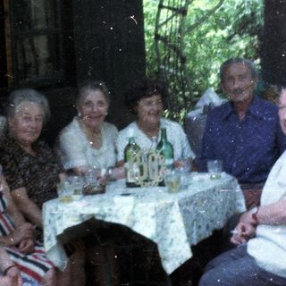 Group of people gathered outdoors for a meal.