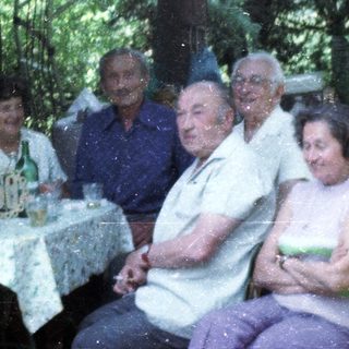 Group of people gathered outdoors for a meal.