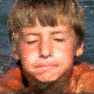 Boy swimming in pool with diving board.