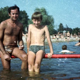 Shallow lake scene with man and boy sitting.