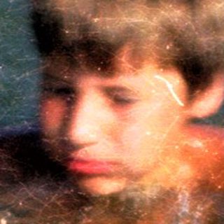 Boy swimming in dark, murky water.