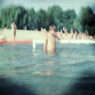People swimming and playing in a lake.