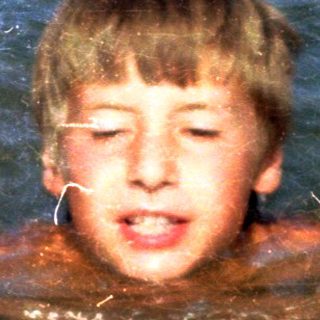 Boy swimming in murky water.