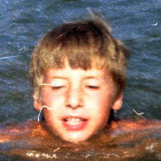 Boy swimming in murky water.