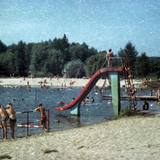 People swimming and sliding at a beachside water park.