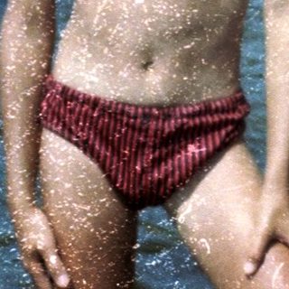 Two boys playing in shallow water at a beach.