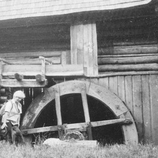 Historic wooden water wheel and log cabin.