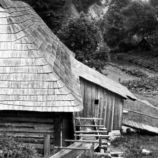 Traditional wooden cabin with steep shingled roof.