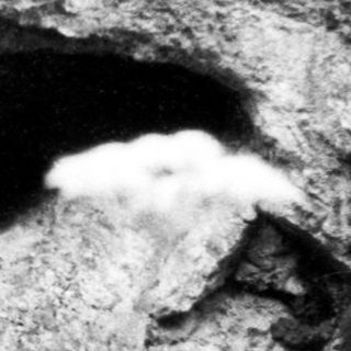 Natural cave entrance in rocky terrain.