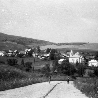 Rural village scene with church and winding road.