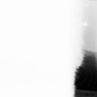 Blurry outdoor scene with sunlit mist or spray.