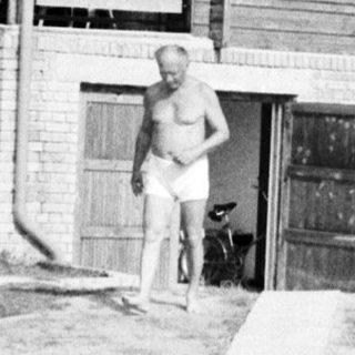 Rural wooden house with person standing near entrance.