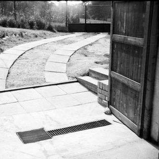 Curved stone pathway leading to wooden door.