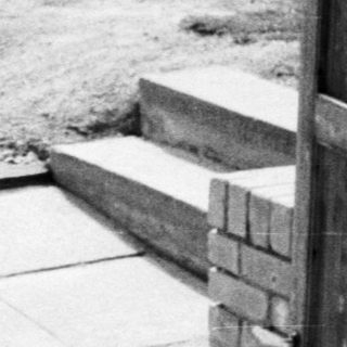 Curved stone pathway leading to wooden door.