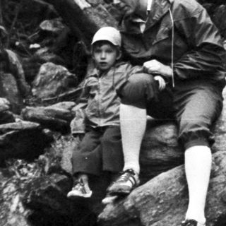 Person rappelling down rocky cliff face.