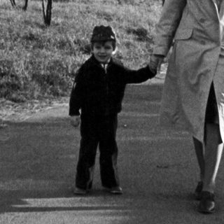 A woman and child walking together outdoors.