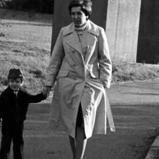 A woman and child walking together outdoors.