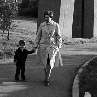 A woman and child walking together outdoors.