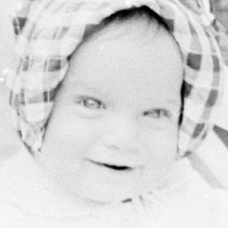 Baby in vintage stroller outdoors.