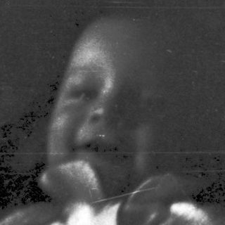 Blurred black-and-white photo of a person playing drums.