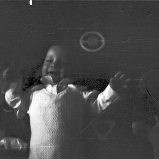 Blurred black-and-white photo of a person playing drums.