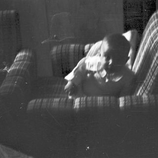 Blurred indoor scene of person sitting on couch.
