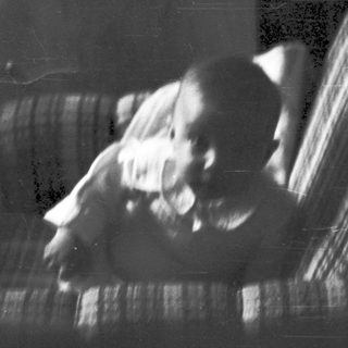 Blurred indoor scene of person sitting on couch.