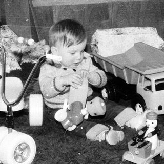 Young child playing with vintage electronic toys.