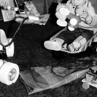Child playing with toys near decorated Christmas tree.