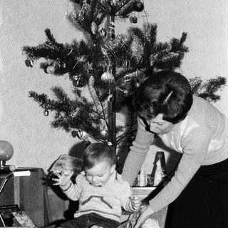 Family decorating Christmas tree with child.